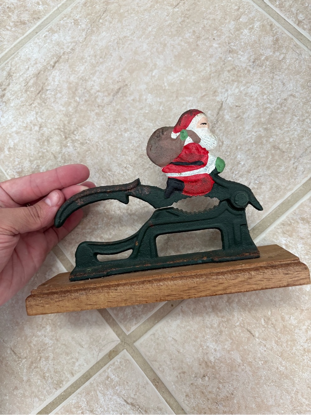vintage cast-iron nutcracker shaped like Santa Claus on a wooden base
